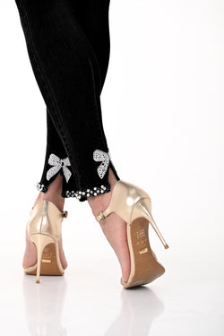 Pantalon noir Frank Lyman 191116U avec détails strass et nœuds à l'arrière des chevilles. Coupe flatteuse, confort optimal. Parfait pour le bureau, soirées et occasions spéciales.