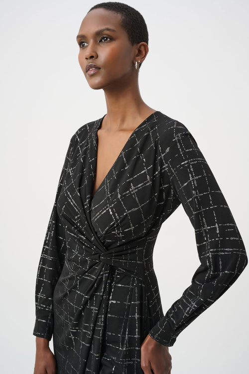 Robe portefeuille Joseph Ribkoff 264186 en jersey noir avec quadrillage métallisé argenté. Col V croisé, nœud taille, manches longues, longueur midi. Parfaite soirée ou bureau.
