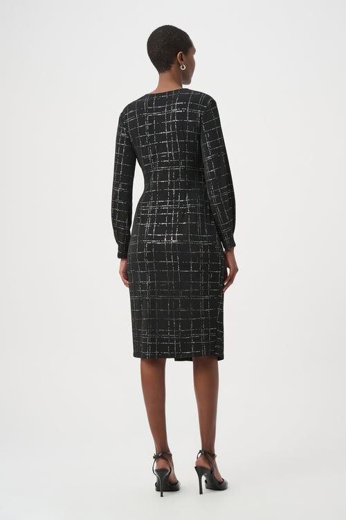 Robe portefeuille Joseph Ribkoff 264186 en jersey noir avec quadrillage métallisé argenté. Col V croisé, nœud taille, manches longues, longueur midi. Parfaite soirée ou bureau.