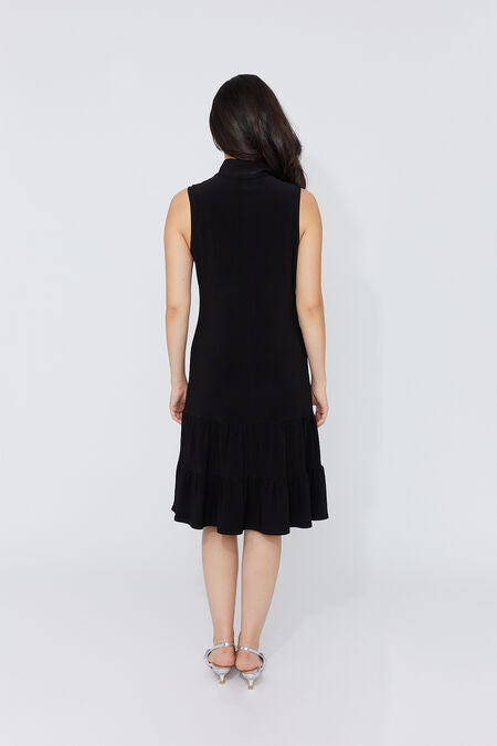 Robe Noire Zip Volant Compli K (33952) — pour la femme qui réinvente la petite robe noire à chaque porté, qui la choisit quand l’occasion mérite d’être à la hauteur et qui sait qu’un détail change tout