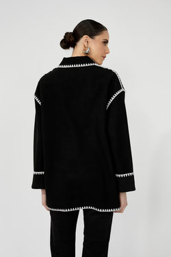 Manteau en laine noire Frank Lyman 251734 avec surpiqûres blanches contrastantes. Élégant, chaud et polyvalent. Parfait pour l'automne et l'hiver québécois.