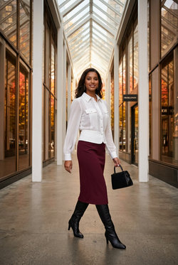 Jupe bordeaux et bottes noires dans une arcade contemporaine