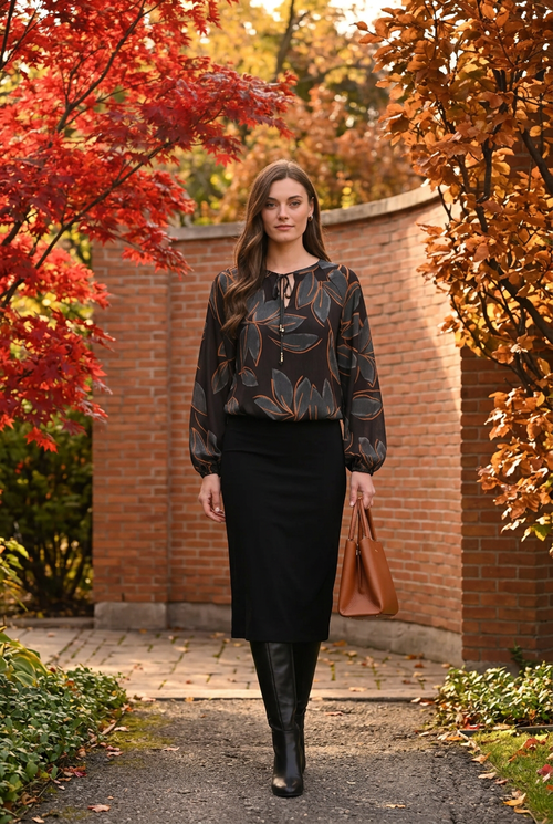 Jupe noire, bottes ajustées et sac cognac