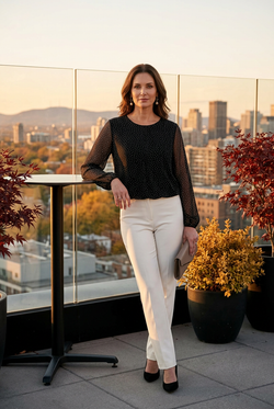 Pantalon ivoire et pochette taupe sur une terrasse panoramique